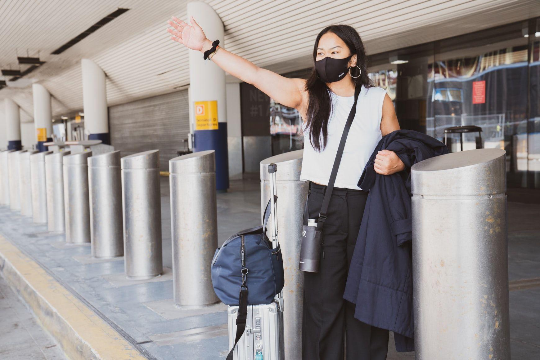 A women on the airport waving for the taxi