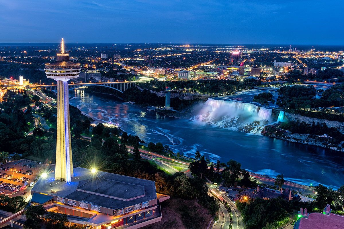 Illuminated Skylon Tower and evening cityscape with American Falls